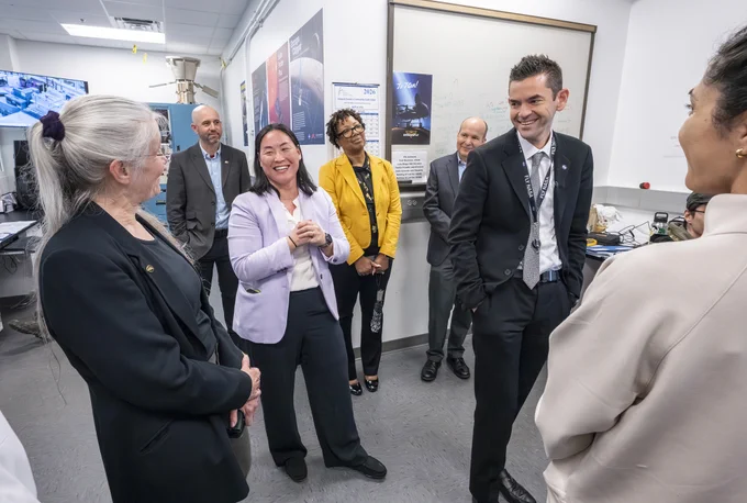 Elizabeth Turtle (left), Dragonfly’s principal investigator from APL, discusses the mission with Isaacman (right) and team. (Credit: Johns Hopkins APL/Craig Weiman)