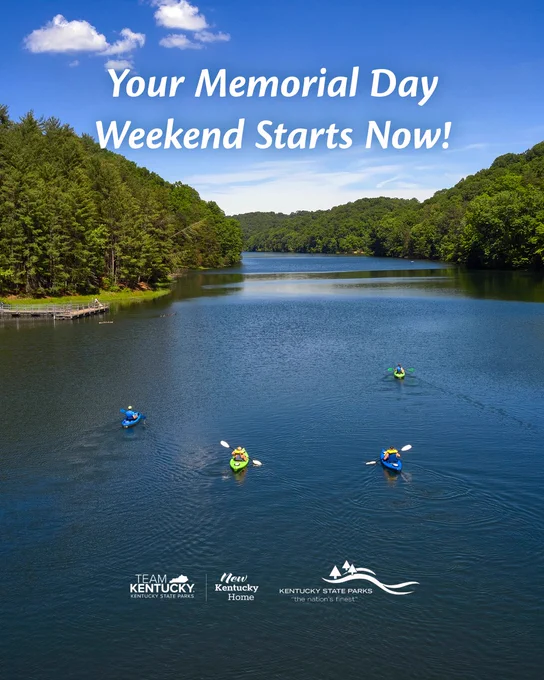 A scenic view of a calm lake surrounded by lush green trees under a clear blue sky. Several individuals are kayaking on the water. Text at the top says, "Your Memorial Day Weekend Starts Now!" Logos for Team Kentucky, Kentucky: Your Own, and Kentucky State Parks are at the bottom.