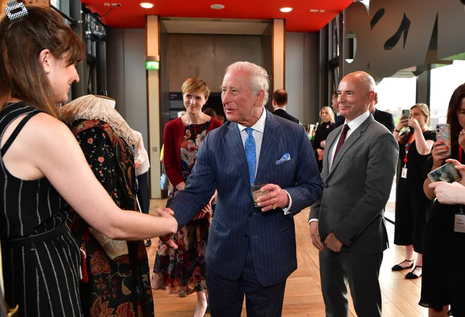His Majesty the King at the Royal Shakespeare Theatre. HIs Majesty looks at costumes and shakes hands with an RSC staff member.