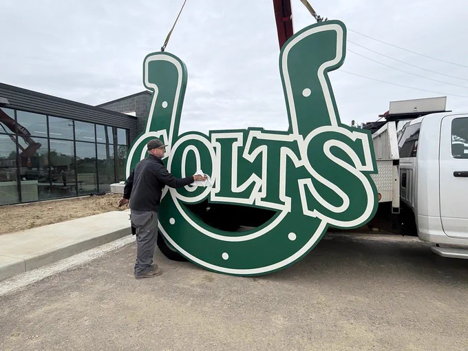 Worker cleaning new Colts sign