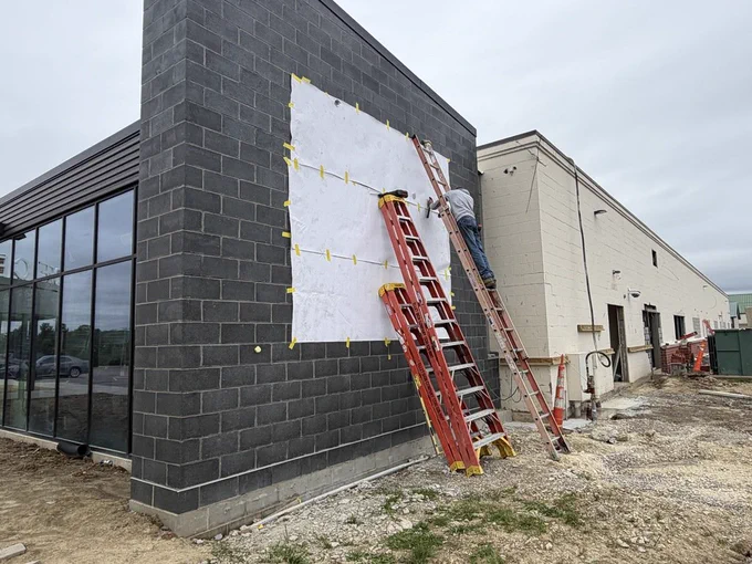 Worker installing brackets to hold new Colts sign