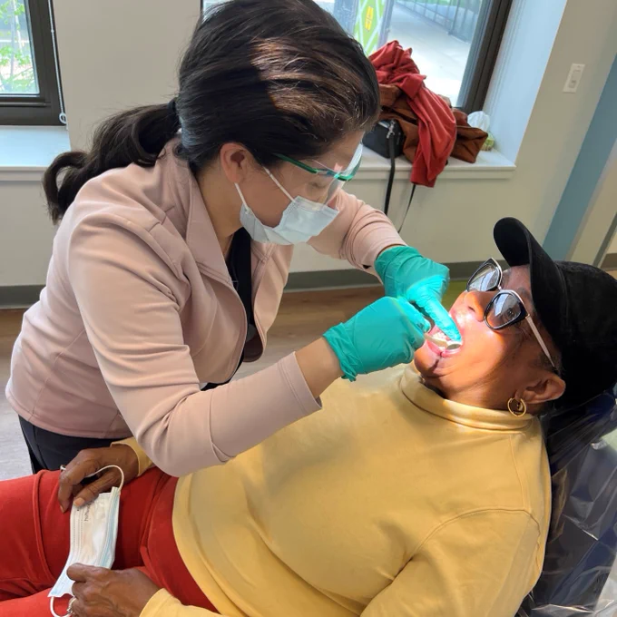Mile Square Health Center Dentist Sodabeh Etminan, DMD, MPH, performs an oral, head and neck cancer screening exam.