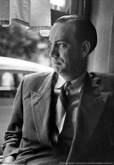 Black and white photo of Camilo José Cela gazing out a window with a reflective demeanour.