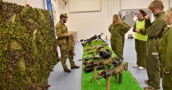 An Army Reservist showcasing weapons to six Forth Valley Chamber of Commerce members.