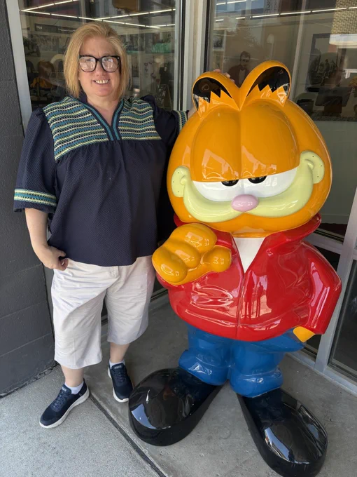 Person posing with Garfield statue. 