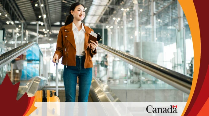 Traveller walking through an airport with luggage and travel documents.