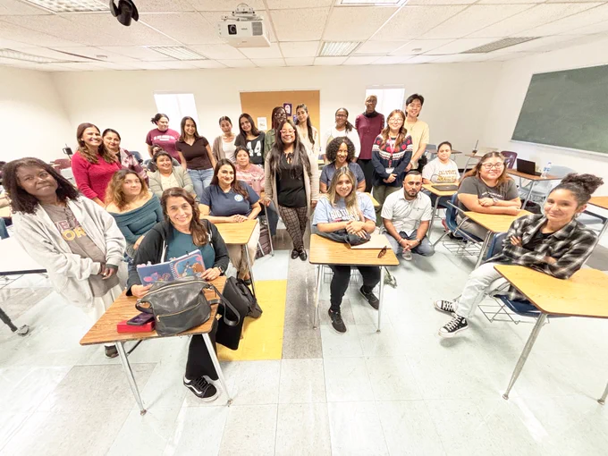Group photo of PK-3 credential students, some standing and other sitting, inside a classroom