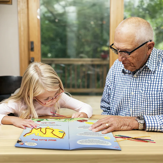 Grandfather and granddaughter enjoying the Adventures Across America USA Fun Book!