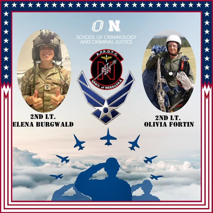 Outside border is stars and stripes. Background is the sky with clouds. Blue silhouettes of three people saluting at bottom, with 7 blue plane silhouettes above them in a rainbow shape. SCCJ logo at top. In middle, UNL's AFROTC logo with Air Force's logo below it. Picture of 2nd LT. Elena Burgwald in fatigues and night vision goggles at left with her name under it, photo of 2nd LT. Olivia Fortin in skydiving military gear including a parachute slung over her back at right with her name under it.
