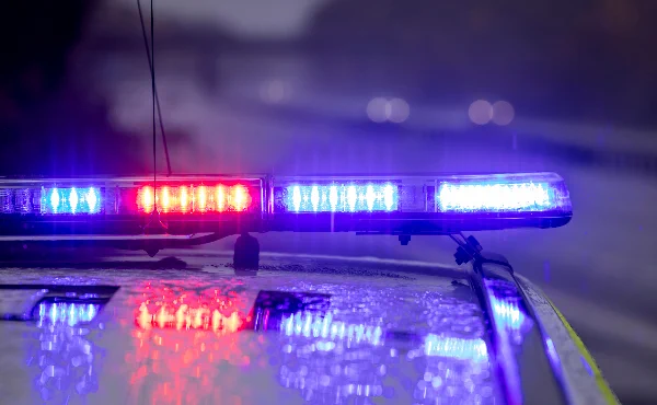 A photo of flashing police car lights in the rain.