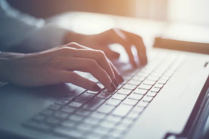 close-up of hands using a computer  keyboard