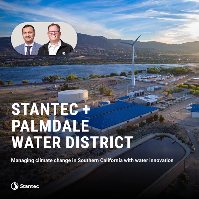 Aerial view of Palmdale Water District facilities with a wind turbine and mountains under a blue sky in Southern California.