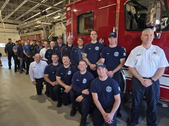 A photo of Deputy Chief Zaremba along with the firefighters that attended the badge pinning standing next to a firetruck.