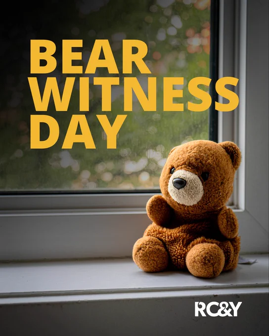 Graphic for Bear Witness Day featuring a brown teddy bear sitting on a windowsill in front of a softly blurred outdoor background. Large yellow text reads “BEAR WITNESS DAY,” and the RCY logo appears in the bottom right corner.
