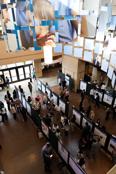 people gather to present posters in large atrium