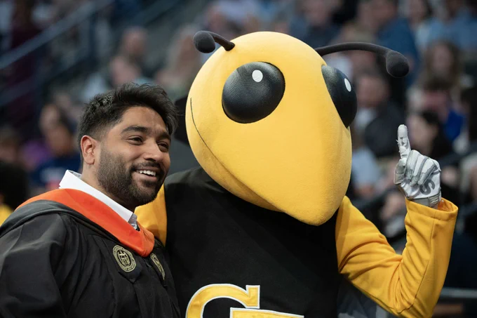 A graduate poses with Buzz.