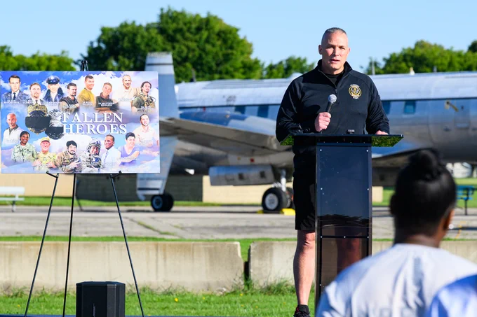 Lieutenant Colonel Joshua Swindell delivers remarks about fallen officers and honoring their memory on a stage. 
