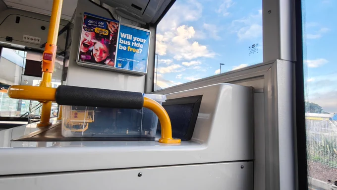 A Lego train packed in a container and placed on the luggage rack of a bus