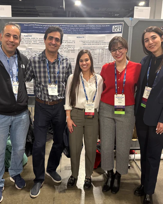 Five researchers in front of research poster. 