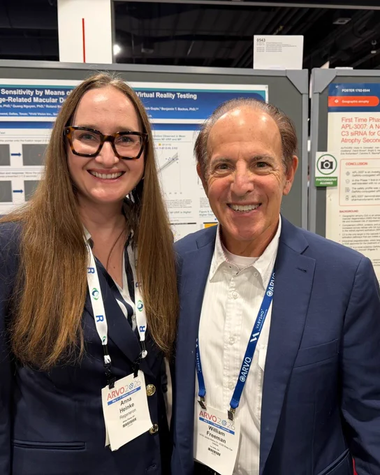 Two researchers standing in front of research posters. 