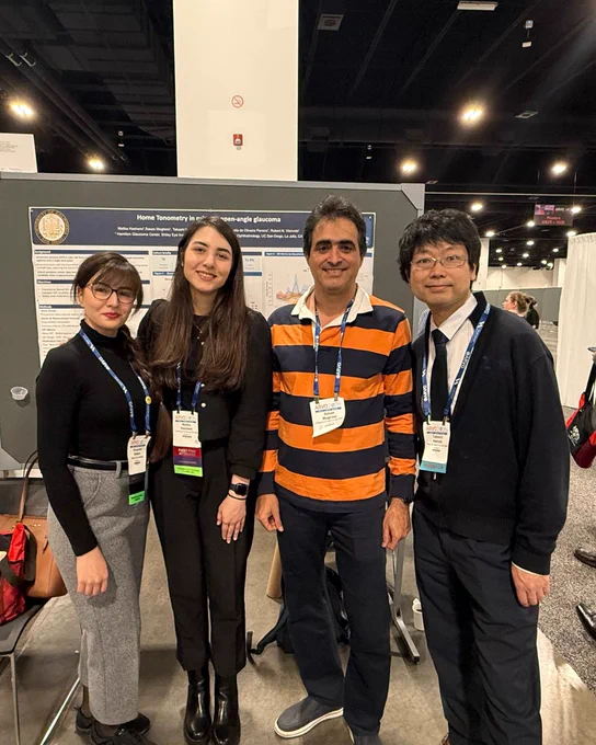 Four researchers in front of research poster.