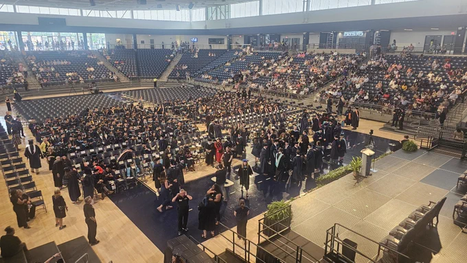 Graduates and attendees find their seats and mingle at the Jack and Ruth Ann Hill Convocation Center during Georgia Southern University's graduate commencement ceremony.