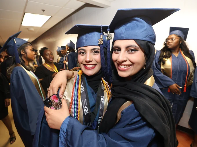 Students posing for camera at graduation ceremony.