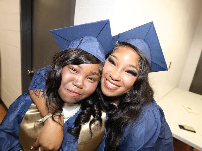 Students posing for camera at graduation ceremony.