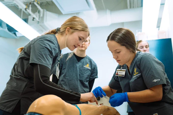 Michigan Tech nursing students practice on a medical mannequin in a clinical lab. 