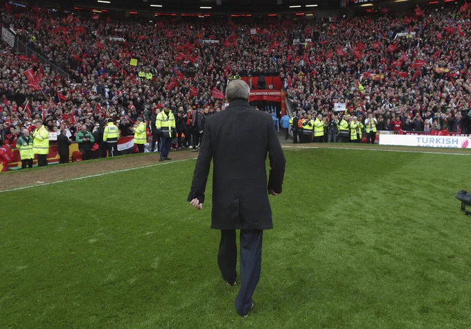 Sir Alex Ferguson walking alone towards the tunnel from the pitch in a  packed Old Trafford.