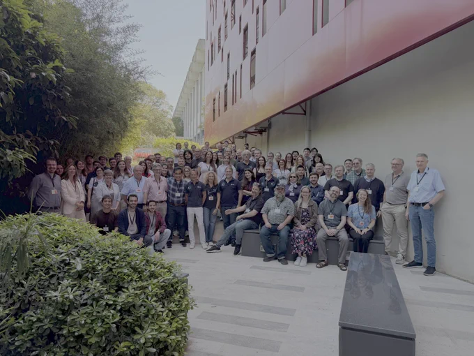 A crowd of researchers outdoors posing for a photo
