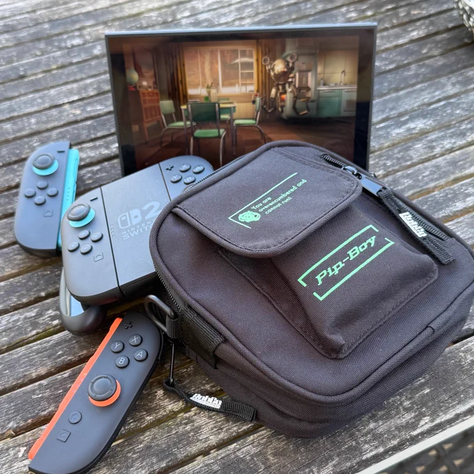 Our Fallout bag filled with Switch 2 controllers, in front of a Switch 2 displaying Fallout 4.