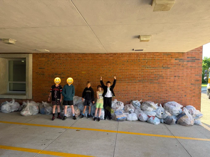 Bowen Elementary students pose for a picture in front of bags of shoe donations.