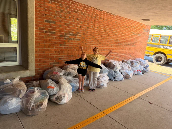 Bowen Elementary students pose for a picture in front of bags of shoe donations.