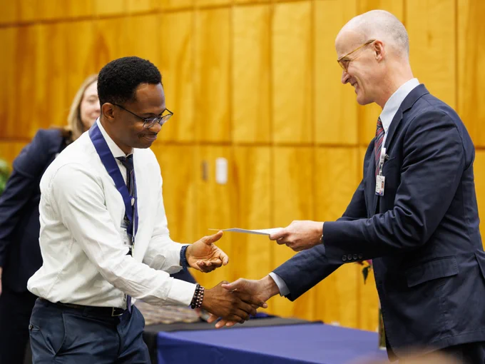 McKing Amedari, a 2025–2026 Honors College member, receives his certificate of completion of the program from Dr. Scott Rodgers.
