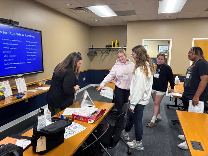 ECOESC staff member speaks with seventh and eighth grade students around a table during the Middle School Career Connections program site visit at the ECOESC Education Field.