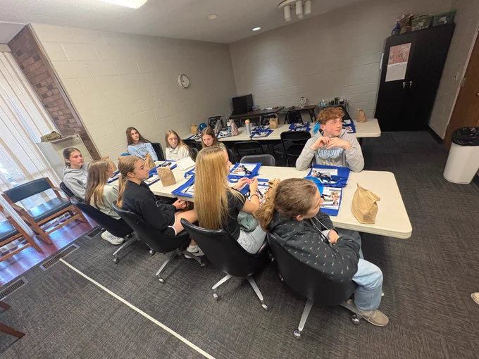 Students listen and engage during a site visit to SpringVale Health Centers, seated around tables as part of the ECOESC Middle School Career Connections career exploration program.