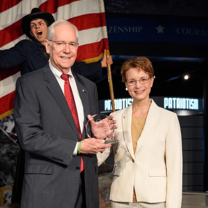 Mr. Harry Fields is holding up an award next to Dr. Deborah Reed.