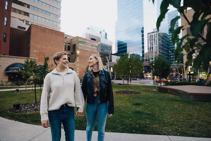 Two women walk through Telus Park in downtown Edmonton.