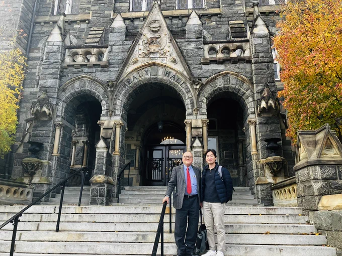 Georgetown Ph.D. student Mideum Hong stands next to his advisor, Professor Peter Phan, left, outside Healy Hall in the fall.