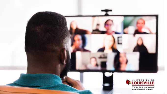 A person is participating in a video conference call with multiple participants visible on the computer screen. 