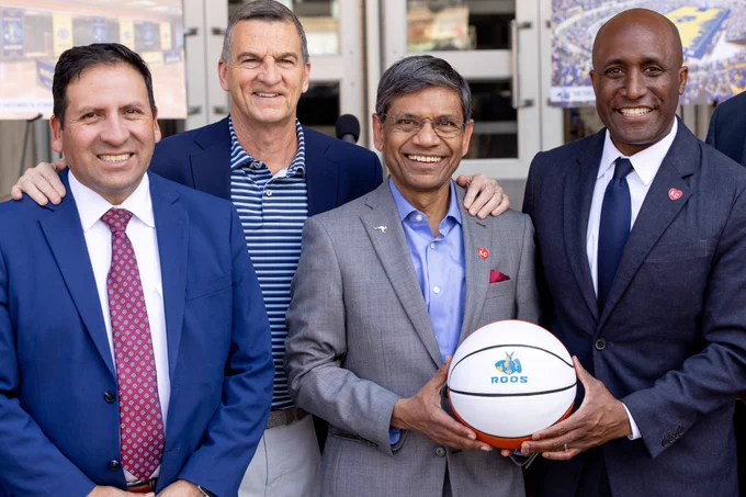 Mario Vasquez, Mark Turgeon, Chancellor Agrawal and Mayor Lucas pose for a photo together. Chancellor Agrawal and Mayor Lucas hold a UMKC basketball between them.