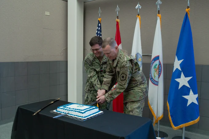Gen. Gregory Guillot, right, and Petty Officer 2nd Class Justin Harvey cut the ceremonial cake during NORAD's 68th Birthday celebration.