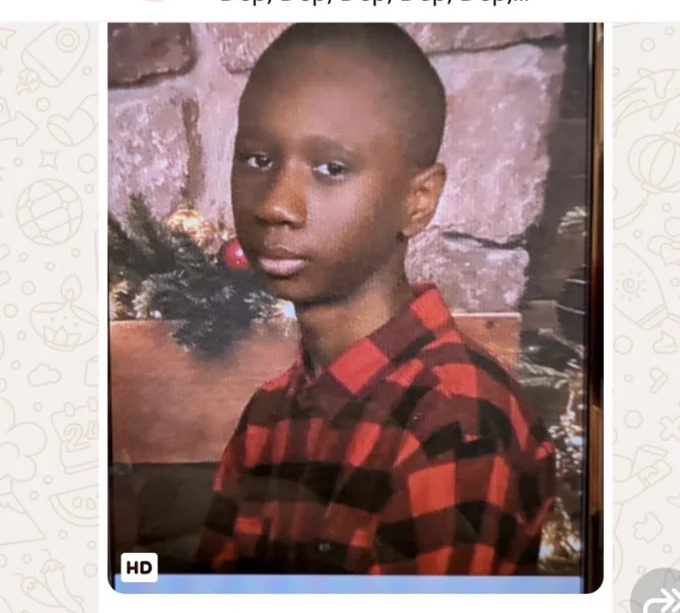 15 year old black male in checkered shirt in front of fireplace