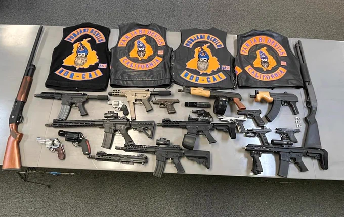 A collection of seized weapons and motorcycle jackets are shown.

