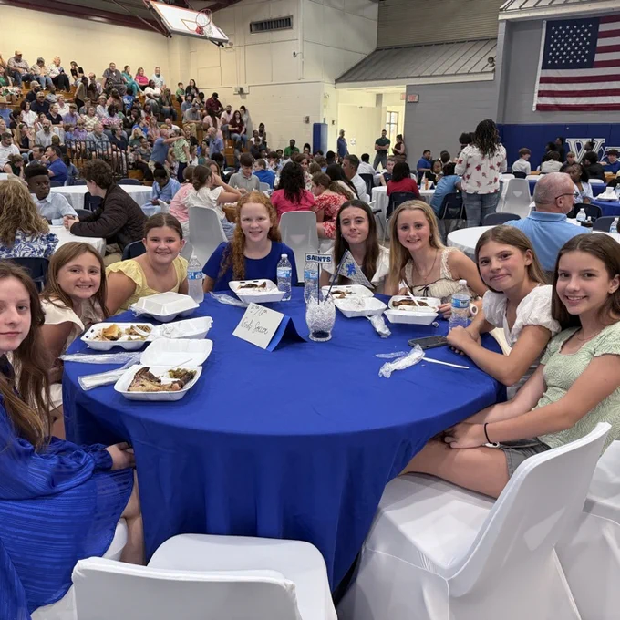 Students sit with teammates. 