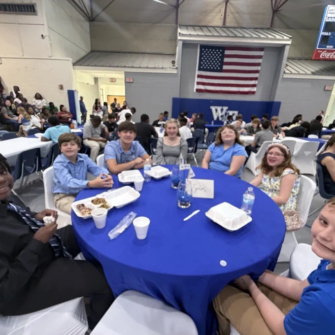 Students sit with teammates. 