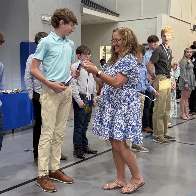 Coach gives athlete a medal