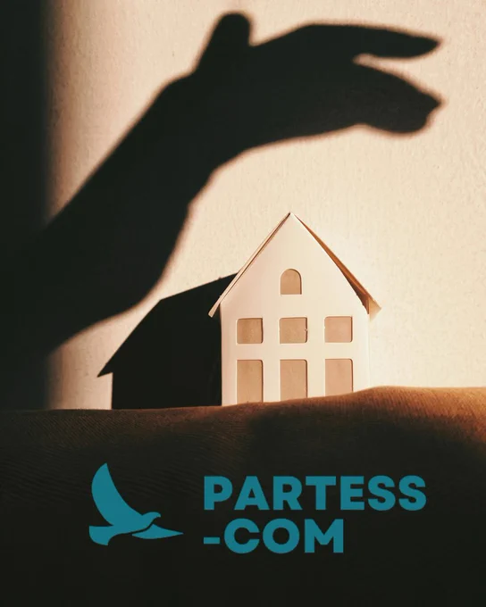 A small white model house is lit against a dark background while the shadow of a large hand looms over it, creating a visual impression of threat and protection. The PARTESS-COM logo appears at the bottom of the image.