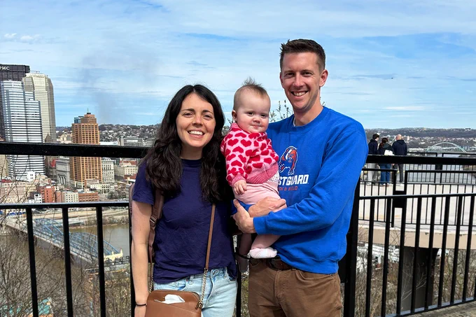 Joe Kelly, his wife and daughter pose for a photo on Mt. Washington, with downtown Pittsburgh in the background. 